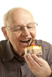 Senior man eating a cake