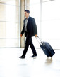 Young business man walking with travel bag