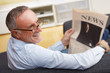 mature man with newspaper at home
