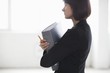 Business woman on holding file in warehouse interior