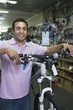 Bike shop assistant stands holding new bike