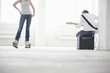 Woman on roller skates and man sitting on amp playing electric guitar