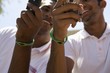 Two young men with wristbands holding mobile phones