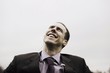 Businessman with MP3 player looks up smiling