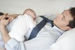 Working father lies sleeping with two week old
