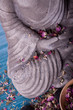 Buddha mit Massage Steinen und Schale voll Blüten