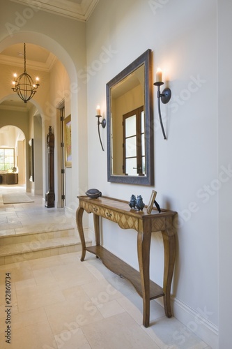 Foto: Antique console table with grey framed mirror in hallway Antique console table with grey framed mirror in hallway