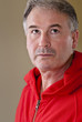 Mature man in red sweater with look of determination