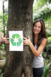 recycling: woman in the forest holding a recycle sign