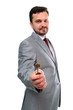 Smiling man in suit holding a key. Focus on key. Smiling man in suit holding a key. Focus on key.