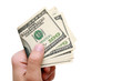 Man holds in his hand a hundred dollars and pays Man holds in his hand a hundred dollars and pays