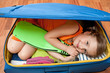Little girl  ready for travel into suitcase