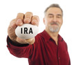 Mature man holds a white nest egg with IRA on it. Mature man holds a white nest egg with IRA on it.