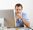 Worried Man at Desk and Computer Paying Bills
