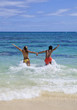 young couple runs into the ocean