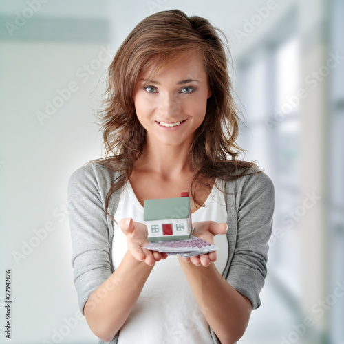 Photo: Woman holding euros bills and house model Woman holding euros bills and house model