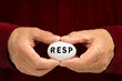Man holds white nest egg with RESP written on it Man holds white nest egg with RESP written on it