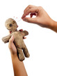 hands holding creepy voodoo doll with needles isolated on white