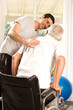 Volunteer helping old man to walk