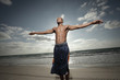 Vivid image of a man on the beach with arms outstretched Vivid image of a man on the beach with arms outstretched