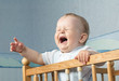 The baby cries and calls mum from a bed