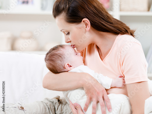 Photo: Mother kissing her sleeping baby Mother kissing her sleeping baby
