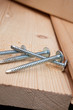 four steel screws on a wooden plank four steel screws on a wooden plank