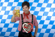 fröhlicher Chinese in Lederhose hält Oktoberfest Maßkrug