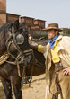 Cowboy standing next to his horse