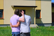 Same-sex couple standing in front of their new house