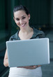 Beautiful smiling young businesswoman holding a laptop