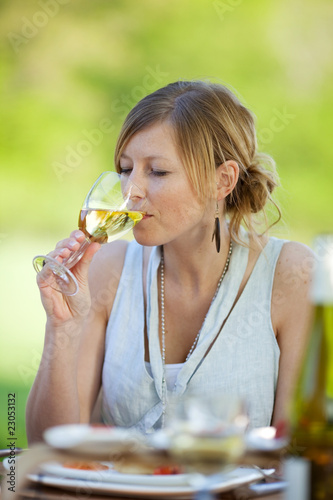 Foto: junge frau trinkt einen weißwein junge frau trinkt einen weißwein
