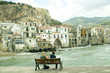 Photo: Couple sitting on a bench near the ocean in Cefalu, Sicily Couple sitting on a bench near the ocean in Cefalu, Sicily