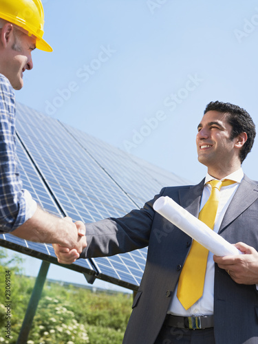 Photo: businessman and electrician shaking hands businessman and electrician shaking hands