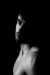 Shadowy dark close-up portrait of young sensual guy
