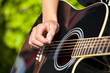 playing a black accoustic guitar