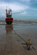 Fishing boat stuck on shore with an anchor