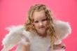 Beautiful little angel girl isolated on pink background