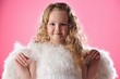 Beautiful little angel girl isolated on pink background