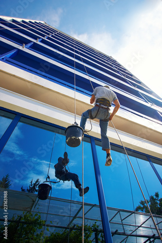 Photo: Workers washing windows in the office building Workers washing windows in the office building