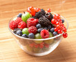 Fruit mix in the glass container, on a table from straw