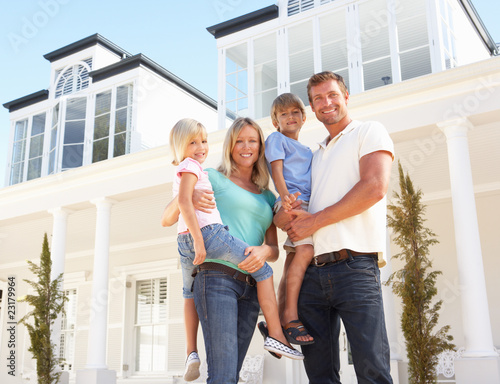 Photo: Young Family Standing Outside Dream Home Young Family Standing Outside Dream Home