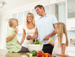 Family Preparing Salad In Modern Kitchen