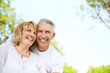 Mature couple smiling and embracing. Focus on the woman.