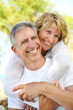 Mature couple smiling and embracing. Focus on the man.