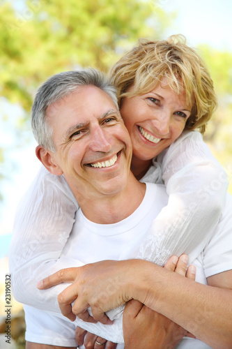 Foto: Mature couple smiling and embracing. Focus on the man. Mature couple smiling and embracing. Focus on the man.