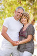 Mature couple smiling and embracing. Focus on the woman.