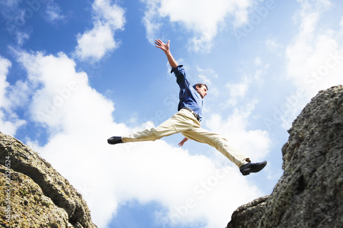 Photo: Businessman jumping over the mountains, business concept Businessman jumping over the mountains, business concept