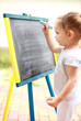 Child drawing with chalk at the blackboard