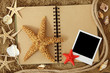Exercise book and sea stars on sand Exercise book and sea stars on sand